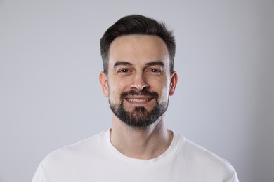 Photo of Portrait of smiling man on grey background, closeup