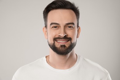 Photo of Portrait of smiling man on grey background, closeup