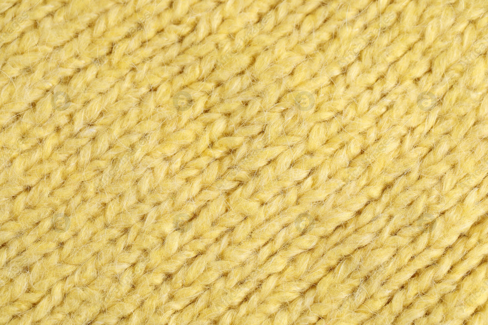 Photo of Texture of yellow wool fabric as background, top view