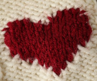 Photo of Texture of beige wool fabric with heart as background, top view