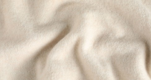 Photo of Texture of beige wool fabric as background, top view