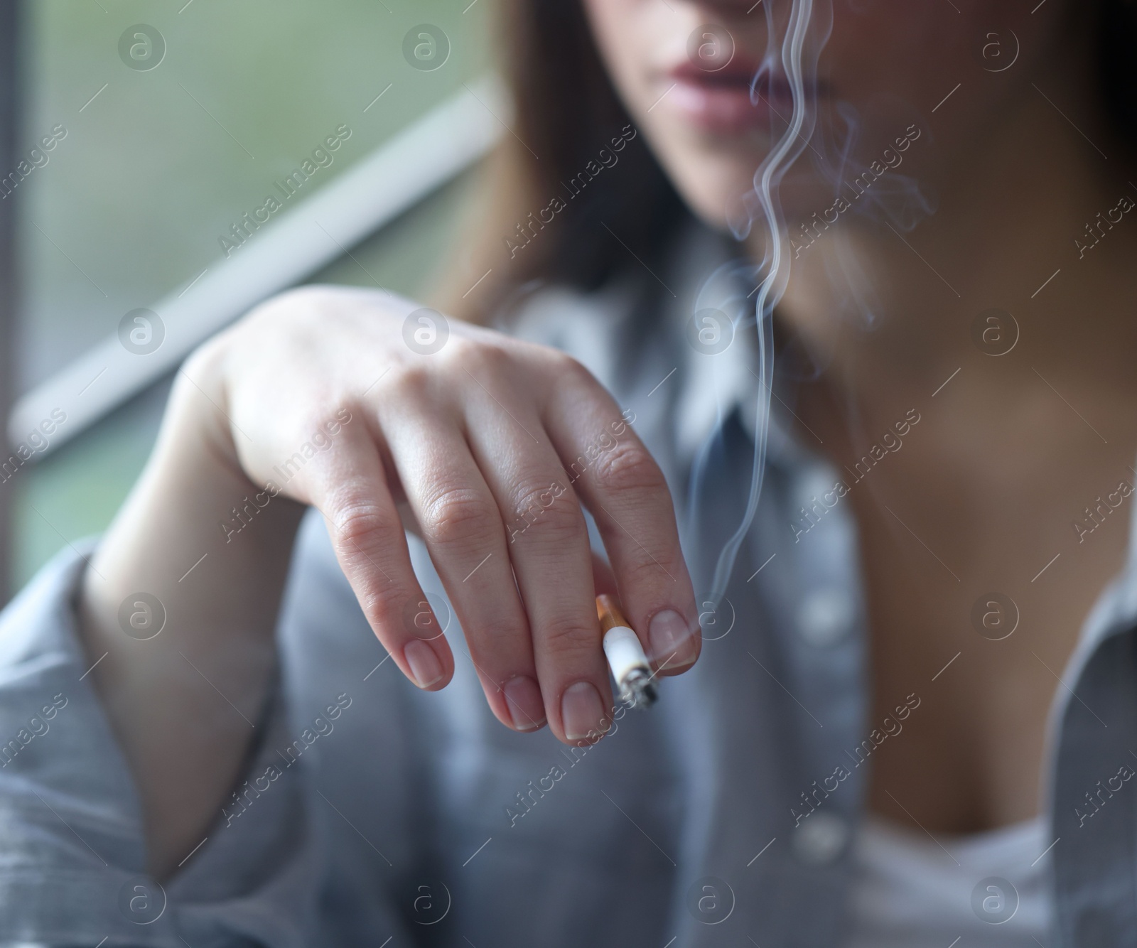 Woman smoking cigarette indoors, selective focus. Bad habit Photo of Woman smoking cigarette indoors, selective focus. Bad habit