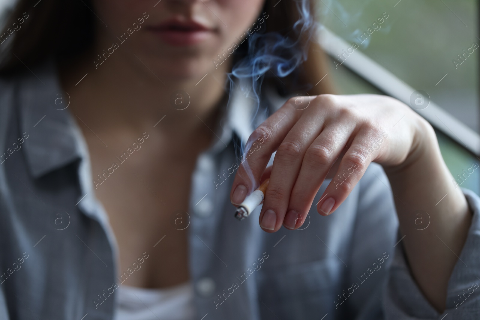 Woman smoking cigarette indoors, selective focus. Bad habit Photo of Woman smoking cigarette indoors, selective focus. Bad habit