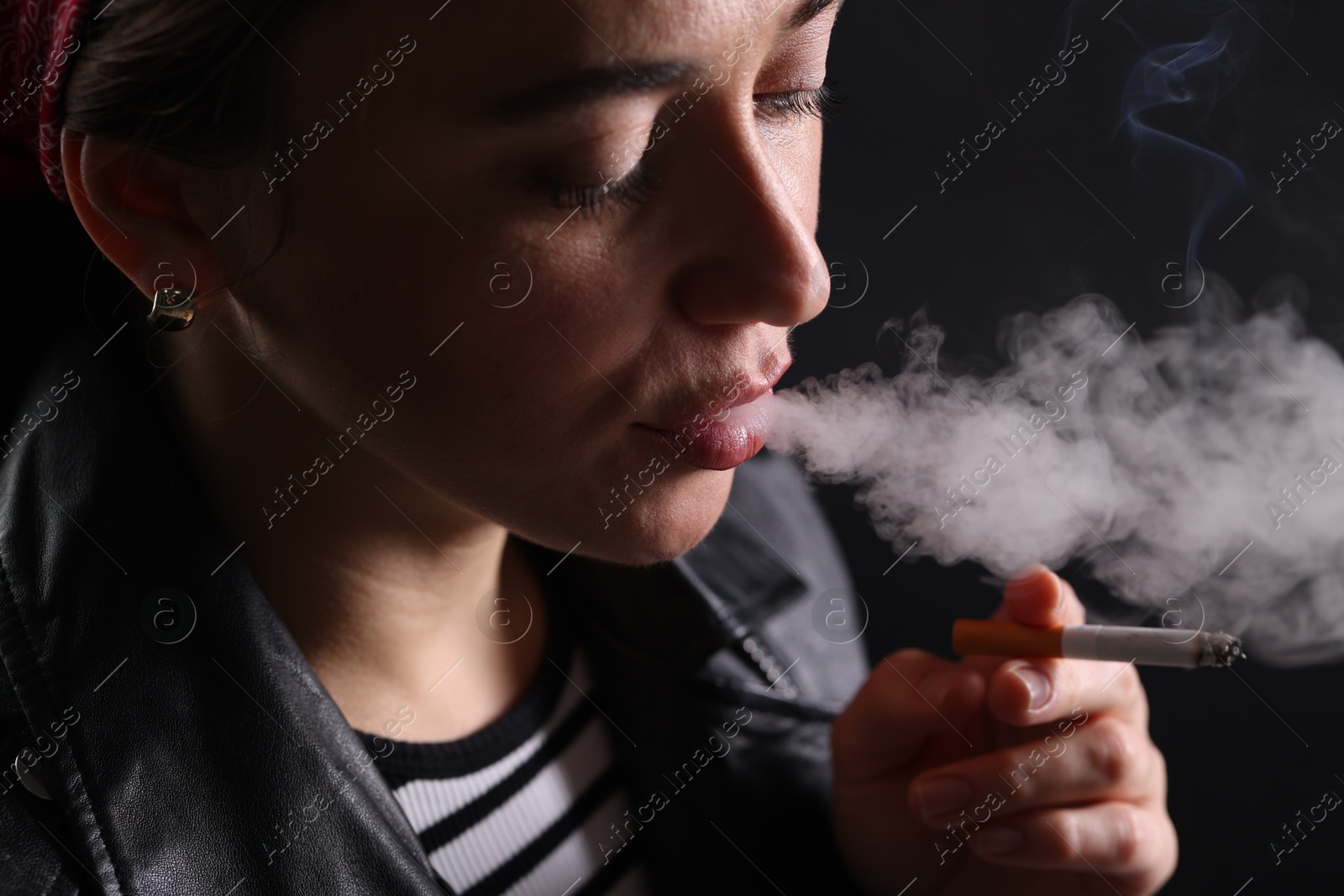 Woman smoking cigarette on black background, closeup Photo of Woman smoking cigarette on black background, closeup