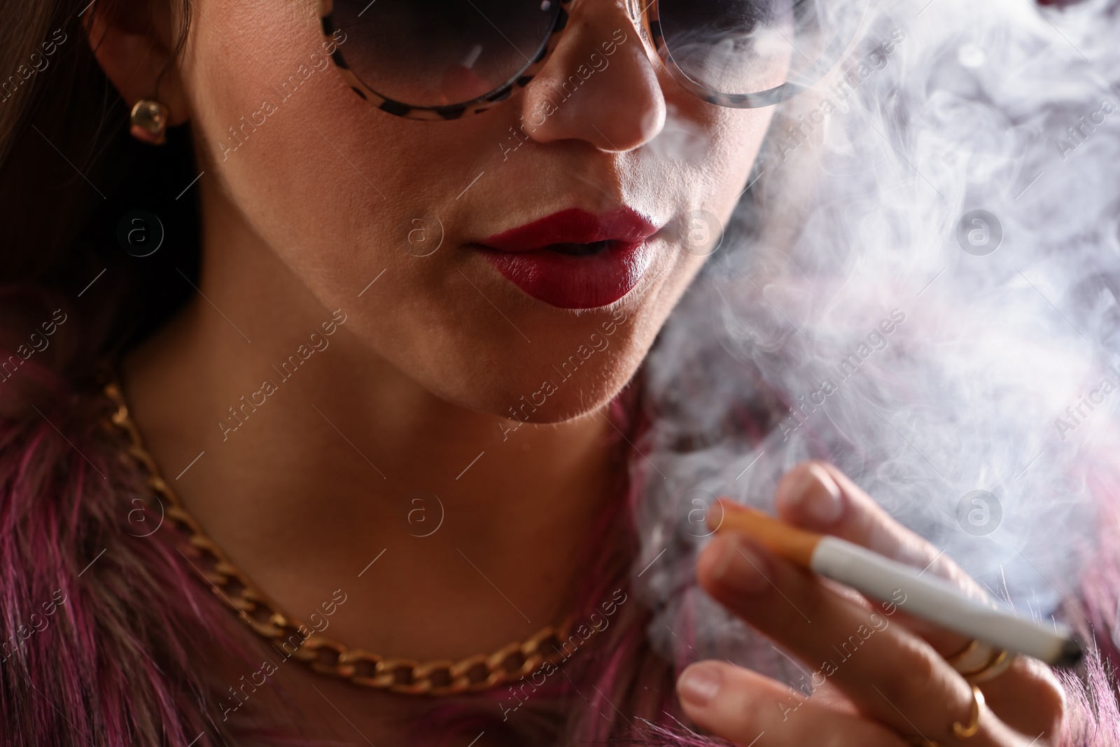 Woman in sunglasses smoking cigarette, closeup. Bad habit Photo of Woman in sunglasses smoking cigarette, closeup. Bad habit
