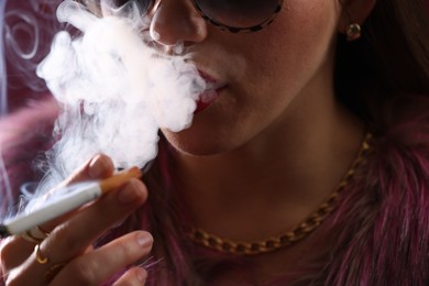 Photo of Woman in sunglasses smoking cigarette, closeup. Bad habit