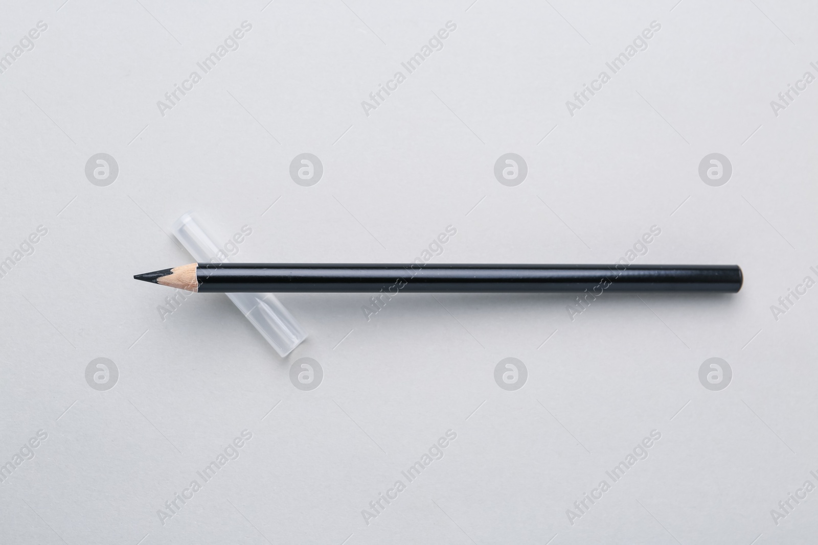 Black eyebrow pencil on light background, top view Photo of Black eyebrow pencil on light background, top view