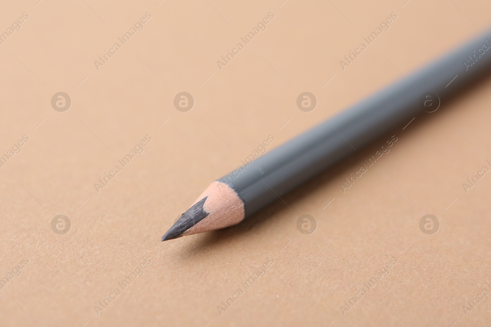 Grey eyebrow pencil on beige background, closeup. Space for text Photo of Grey eyebrow pencil on beige background, closeup. Space for text