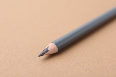 Photo of Grey eyebrow pencil on beige background, closeup. Space for text