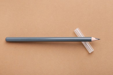 Photo of Grey eyebrow pencil on beige background, top view