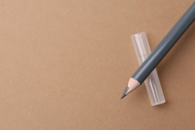 Photo of Grey eyebrow pencil on beige background, top view. Space for text