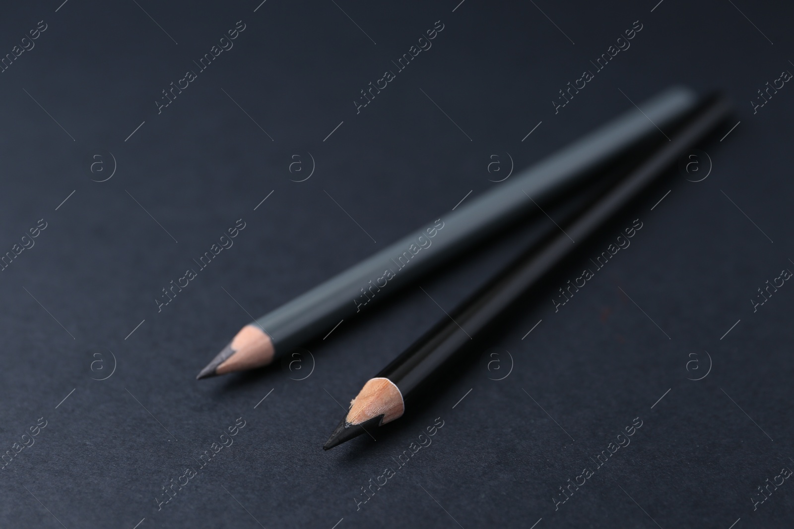 Two different eyebrow pencils on dark background, closeup Photo of Two different eyebrow pencils on dark background, closeup