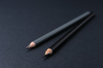 Photo of Two different eyebrow pencils on dark background, closeup