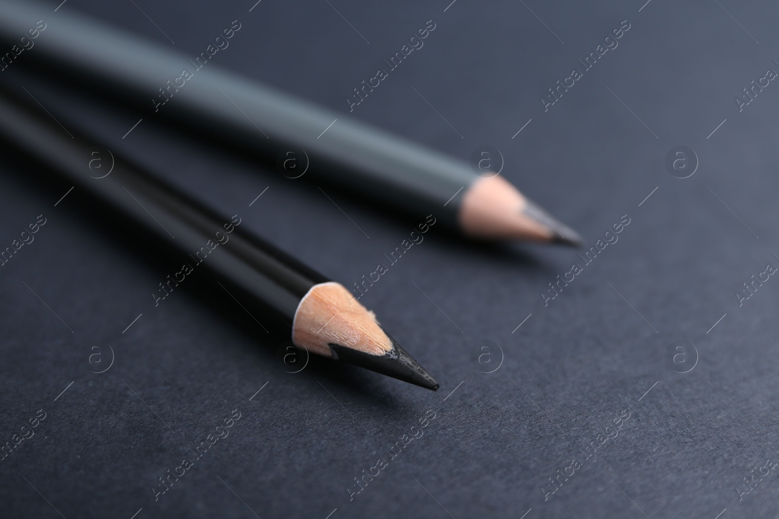 Two different eyebrow pencils on dark background, closeup Photo of Two different eyebrow pencils on dark background, closeup