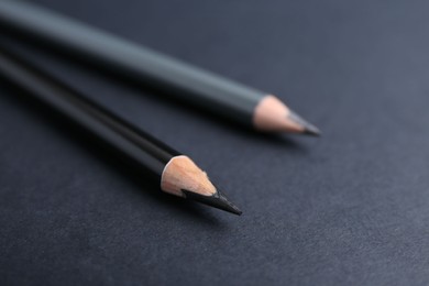 Photo of Two different eyebrow pencils on dark background, closeup