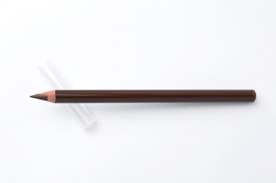 Photo of Brown eyebrow pencil on white background, top view