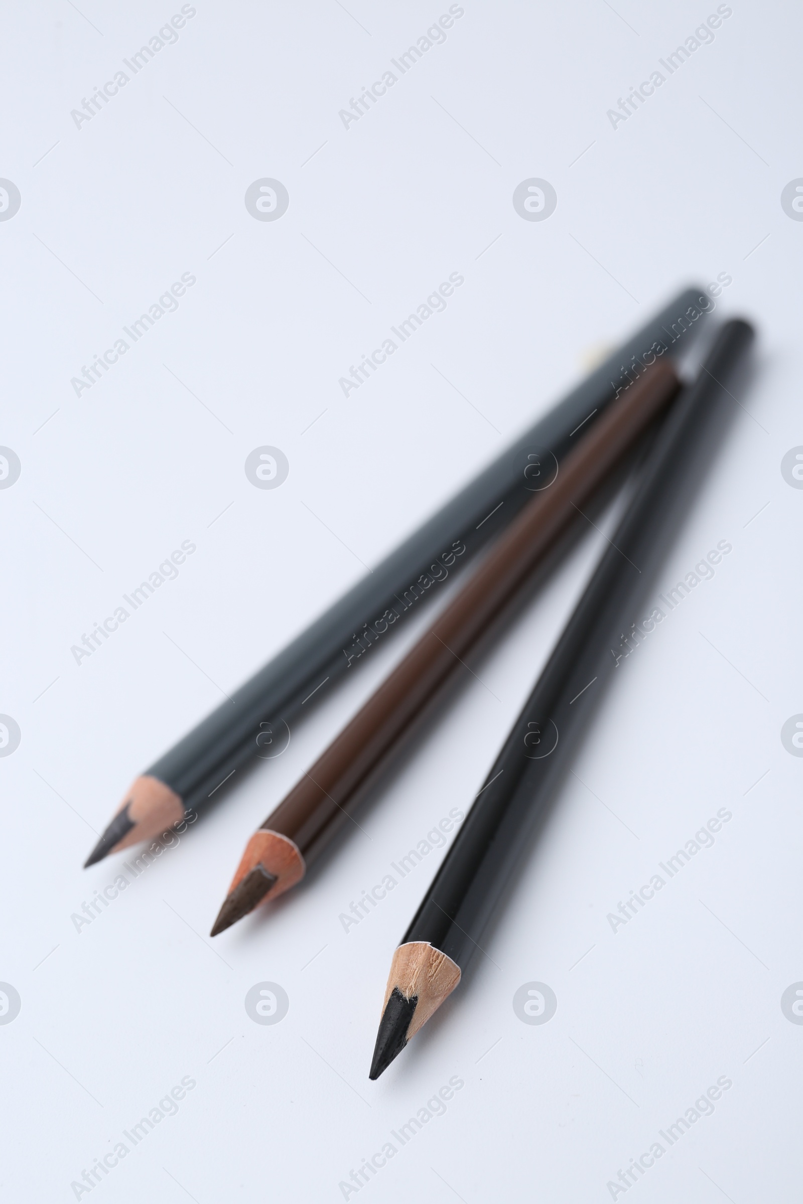 Three different eyebrow pencils on white background, closeup Photo of Three different eyebrow pencils on white background, closeup