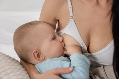 Photo of Mother breastfeeding her little baby indoors, closeup