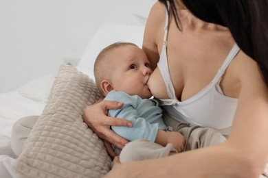 Photo of Mother breastfeeding her little baby indoors, closeup