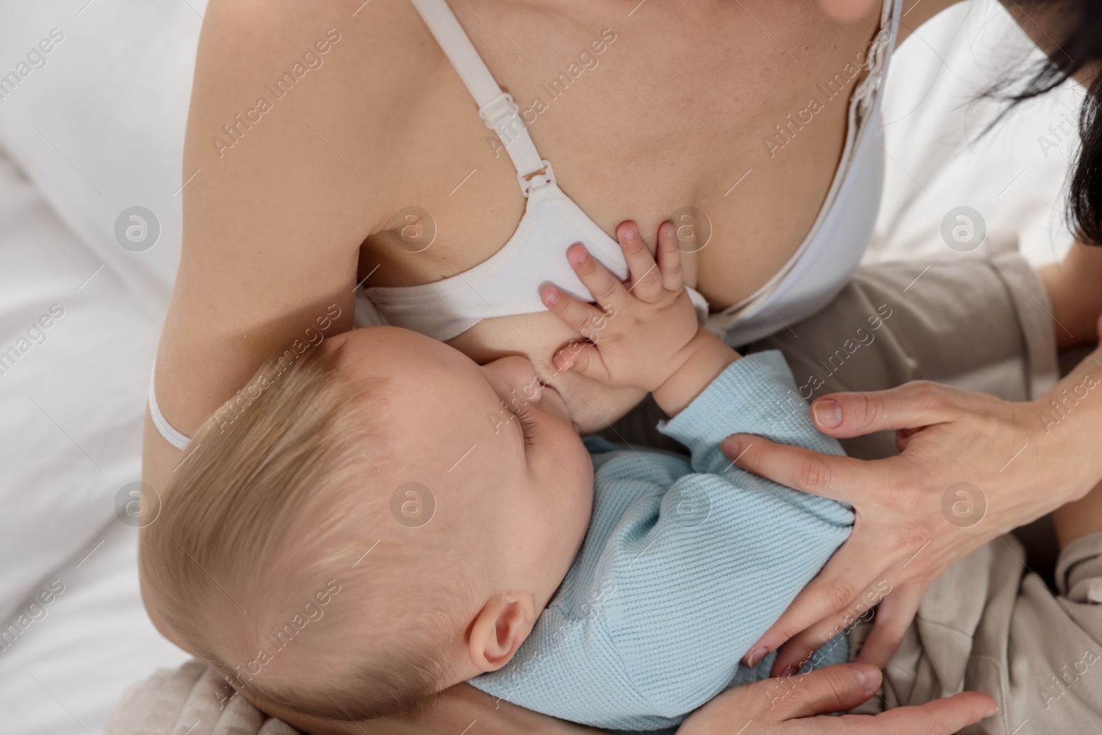 Photo of Mother breastfeeding her little baby indoors, closeup
