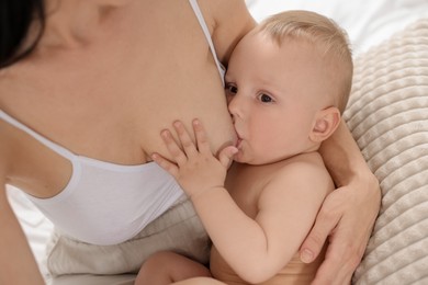 Photo of Mother breastfeeding her little baby indoors, closeup