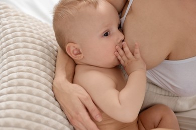 Photo of Mother breastfeeding her little baby indoors, closeup