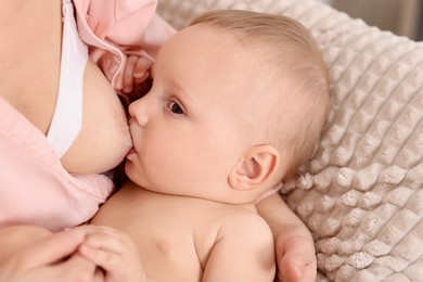 Photo of Mother breastfeeding her little baby indoors, closeup