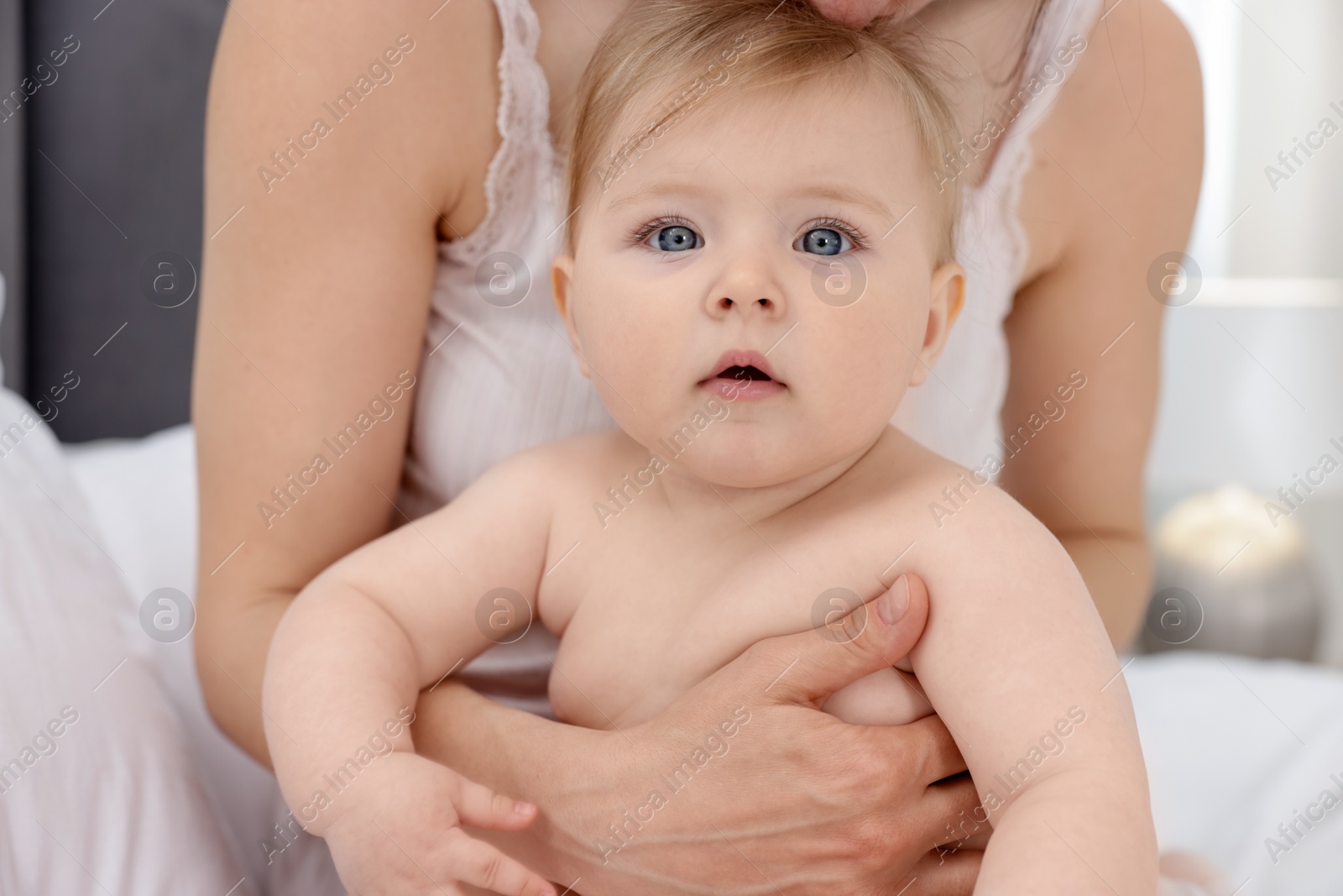 Mother with her little baby on bed at home, closeup Photo of Mother with her little baby on bed at home, closeup