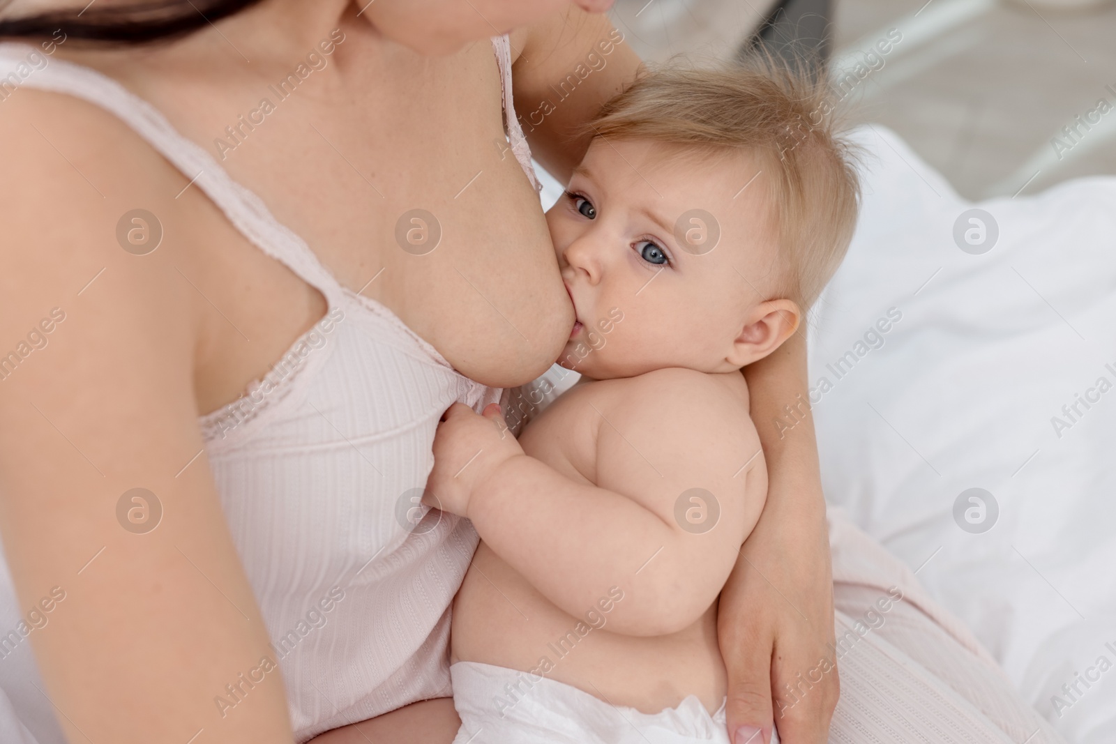 Mother breastfeeding her cute little baby indoors, closeup Photo of Mother breastfeeding her cute little baby indoors, closeup