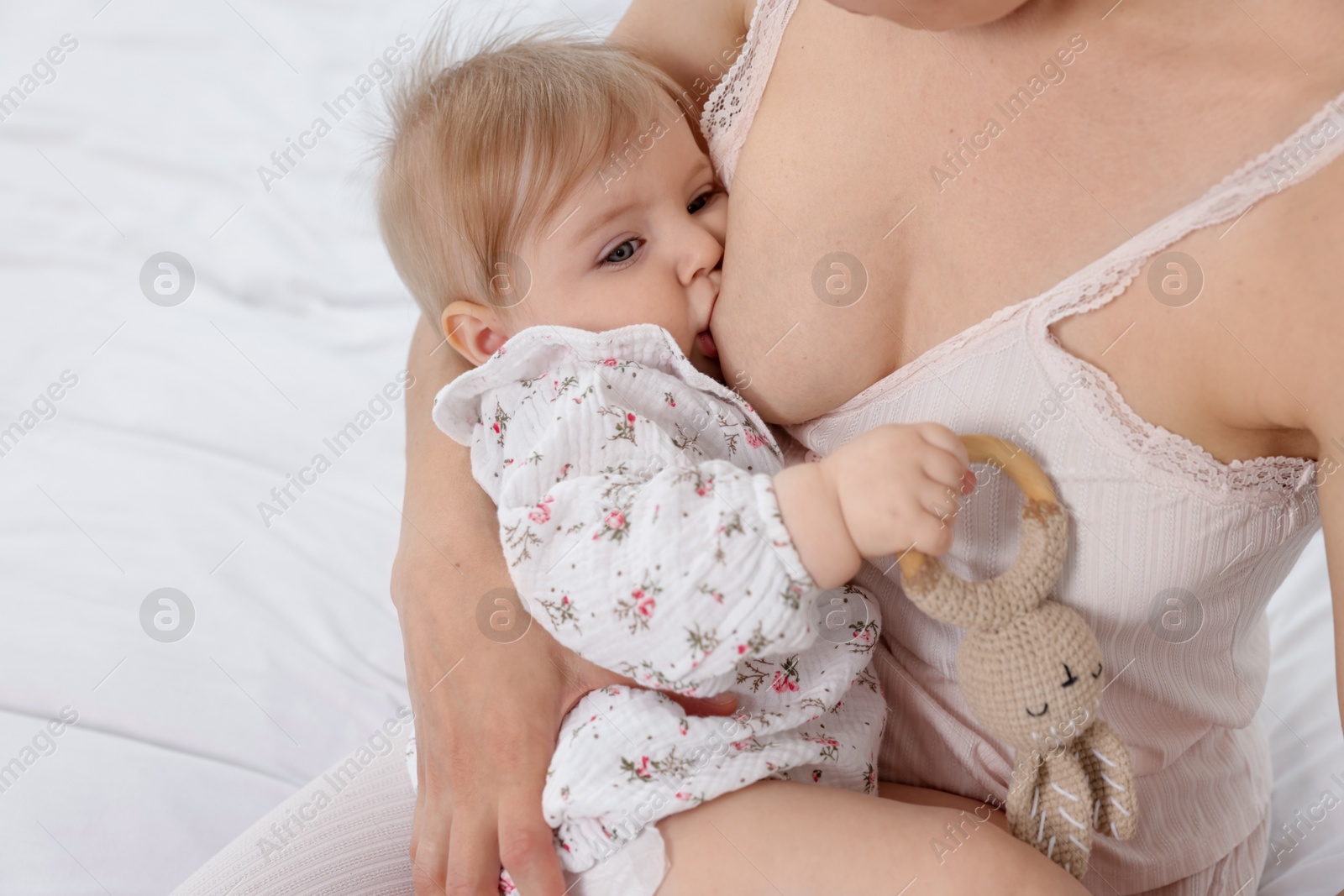 Mother breastfeeding her cute little baby on bed, closeup Photo of Mother breastfeeding her cute little baby on bed, closeup
