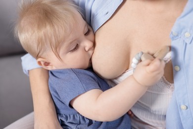 Photo of Mother breastfeeding her little baby indoors, closeup