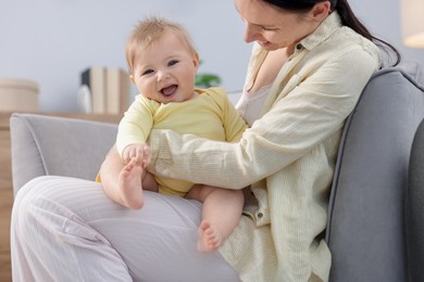 Photo of Mother with her little baby on armchair indoors