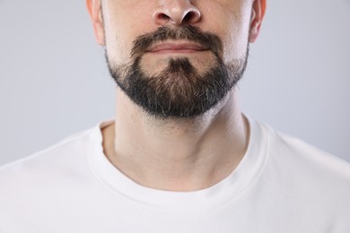 Photo of Man with beard on grey background, closeup