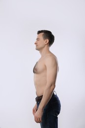 Photo of Man in jeans posing on light grey background
