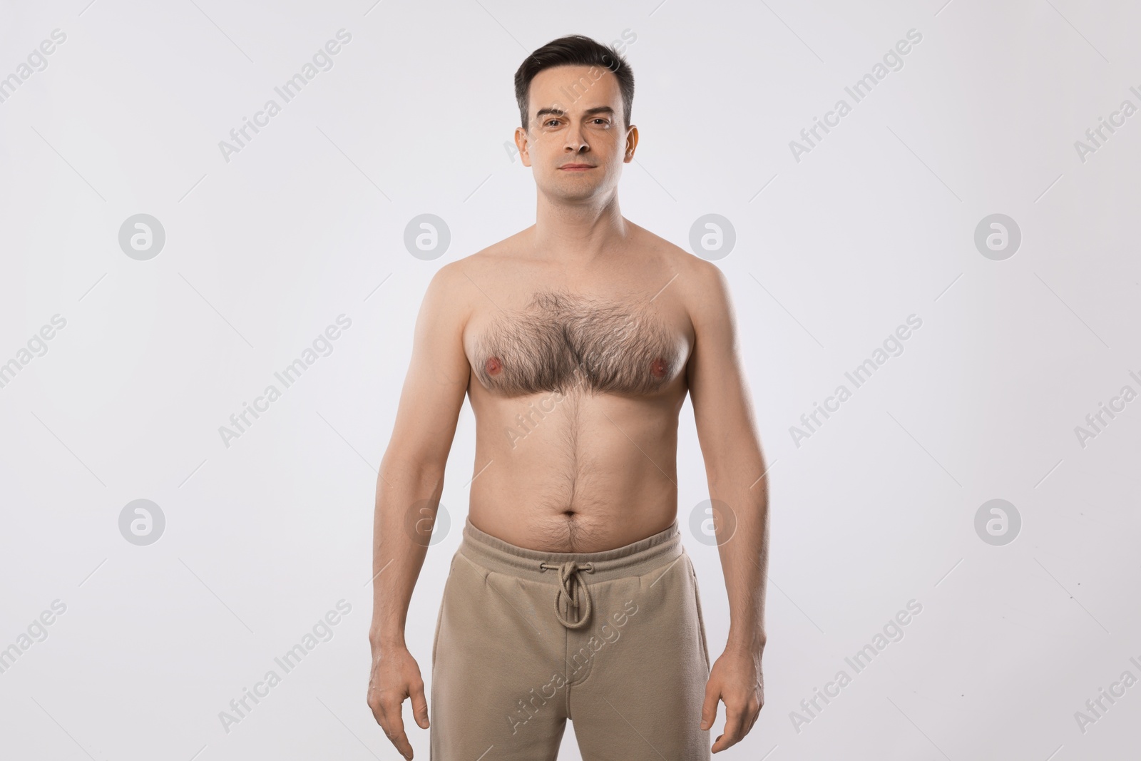 Man in pants posing on light grey background Photo of Man in pants posing on light grey background