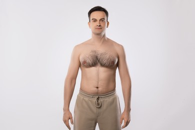 Photo of Man in pants posing on light grey background