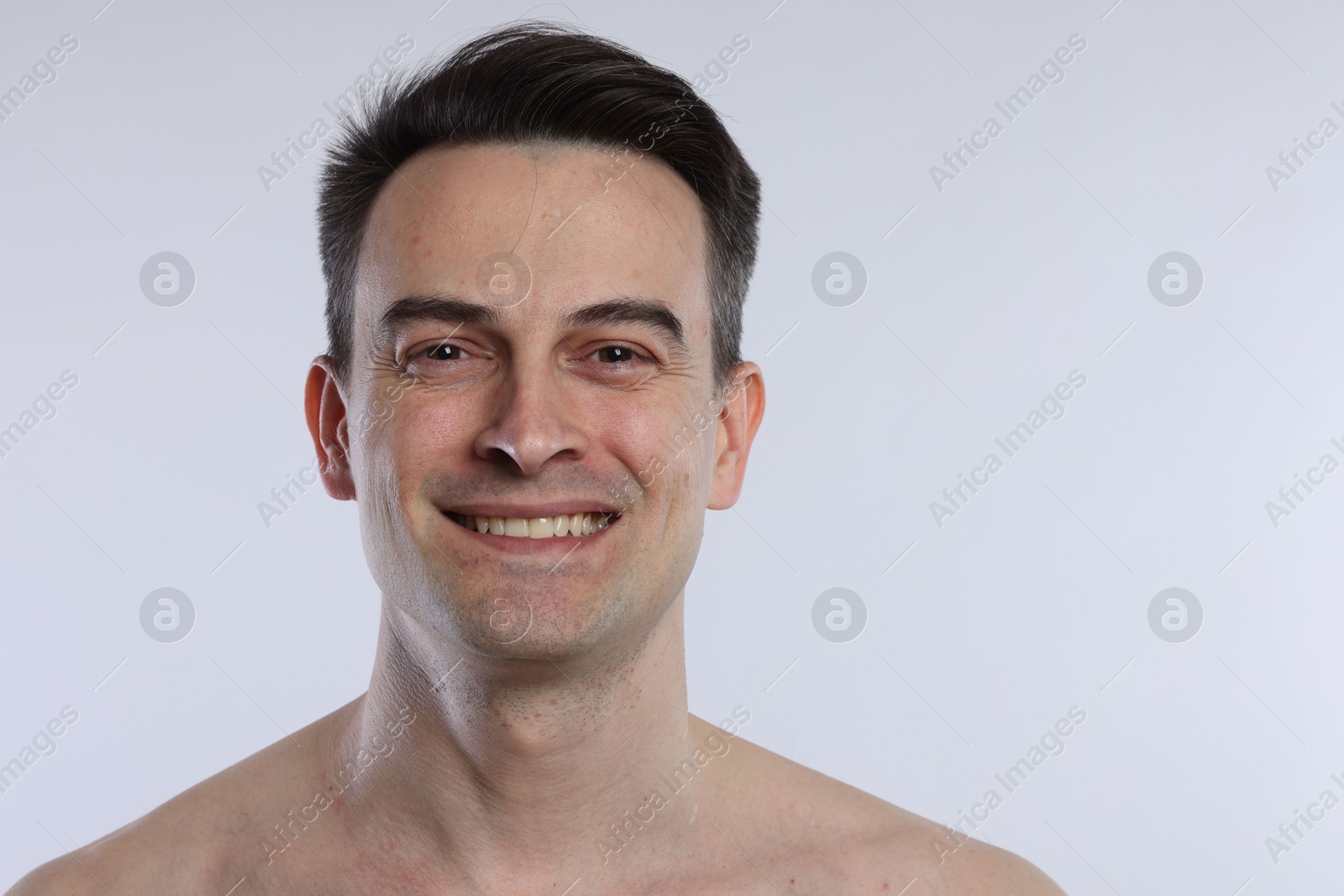 Portrait of smiling man on light grey background, closeup Photo of Portrait of smiling man on light grey background, closeup
