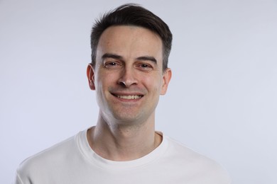 Photo of Portrait of smiling man on light grey background, closeup