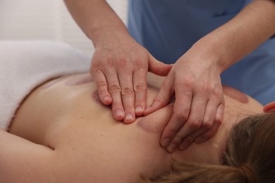 Photo of Cupping therapy. Woman receiving professional massage in spa salon, closeup