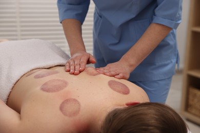 Photo of Cupping therapy. Woman receiving professional massage in spa salon, closeup