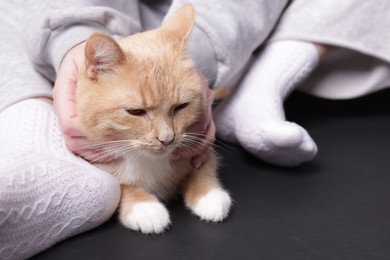 Photo of Woman with cute cat on black background, closeup