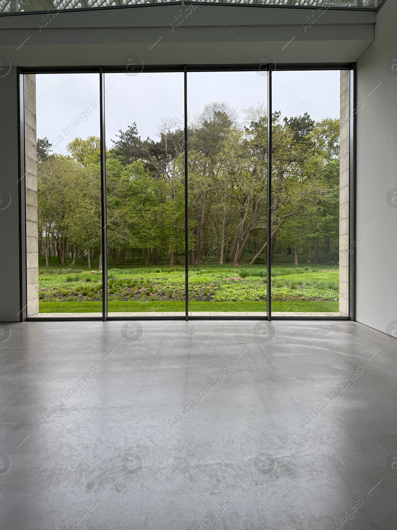 Empty room with panoramic windows and grey floor Photo of Empty room with panoramic windows and grey floor