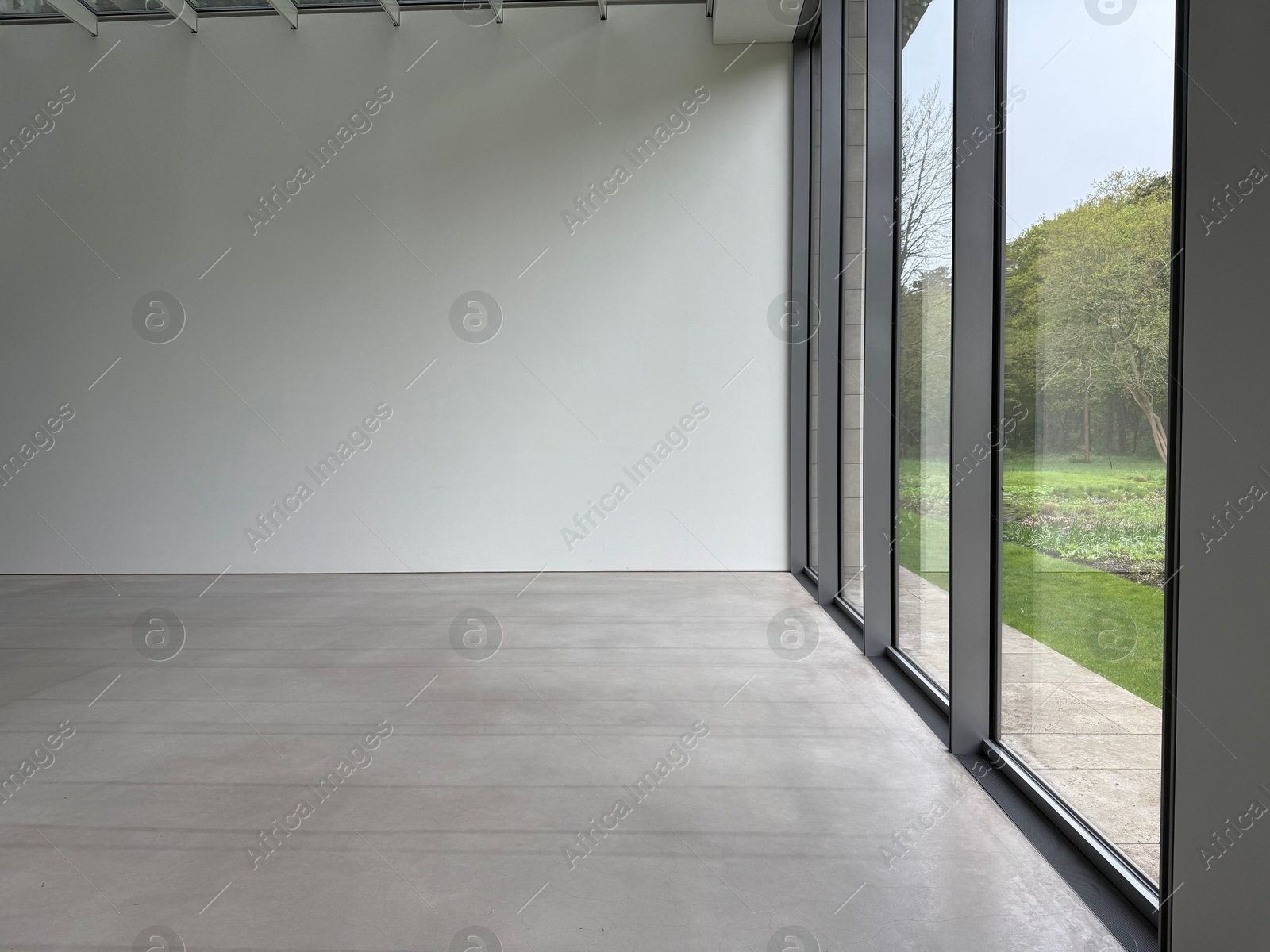 Empty room with panoramic windows and grey floor Photo of Empty room with panoramic windows and grey floor