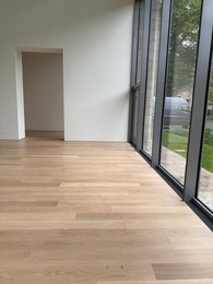 Photo of Empty room with panoramic windows and wooden floor