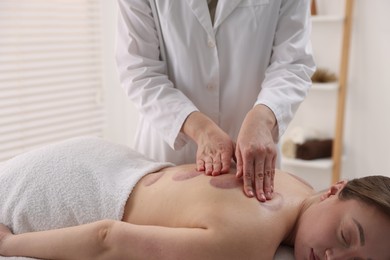 Photo of Cupping therapy. Woman receiving professional massage in spa salon, closeup