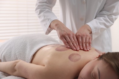 Photo of Cupping therapy. Woman receiving professional massage in spa salon, closeup