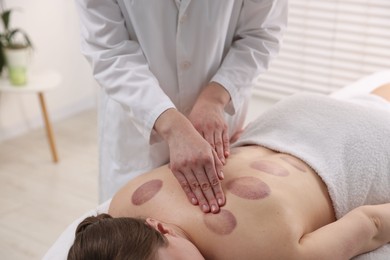 Photo of Cupping therapy. Woman receiving professional massage in spa salon, closeup