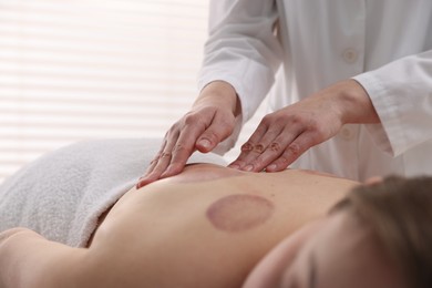 Photo of Cupping therapy. Woman receiving professional massage in spa salon, closeup