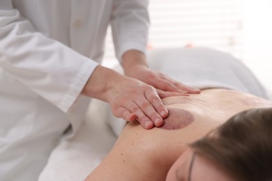 Photo of Cupping therapy. Woman receiving professional massage in spa salon, closeup