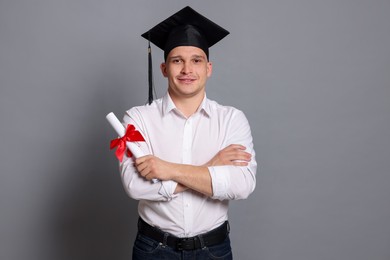 Photo of Happy student with diploma after graduation on grey background